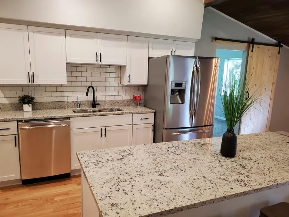 A newly renovated kitchen featuring white cabinets, subway tile, and granite countertops by Phillips Home Improvements LLC in Philadelphia, PA.