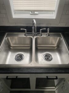 A newly installed kitchen sink and faucet, showcasing plumbing work by Aaron's Handyman Service in Tucson, AZ.