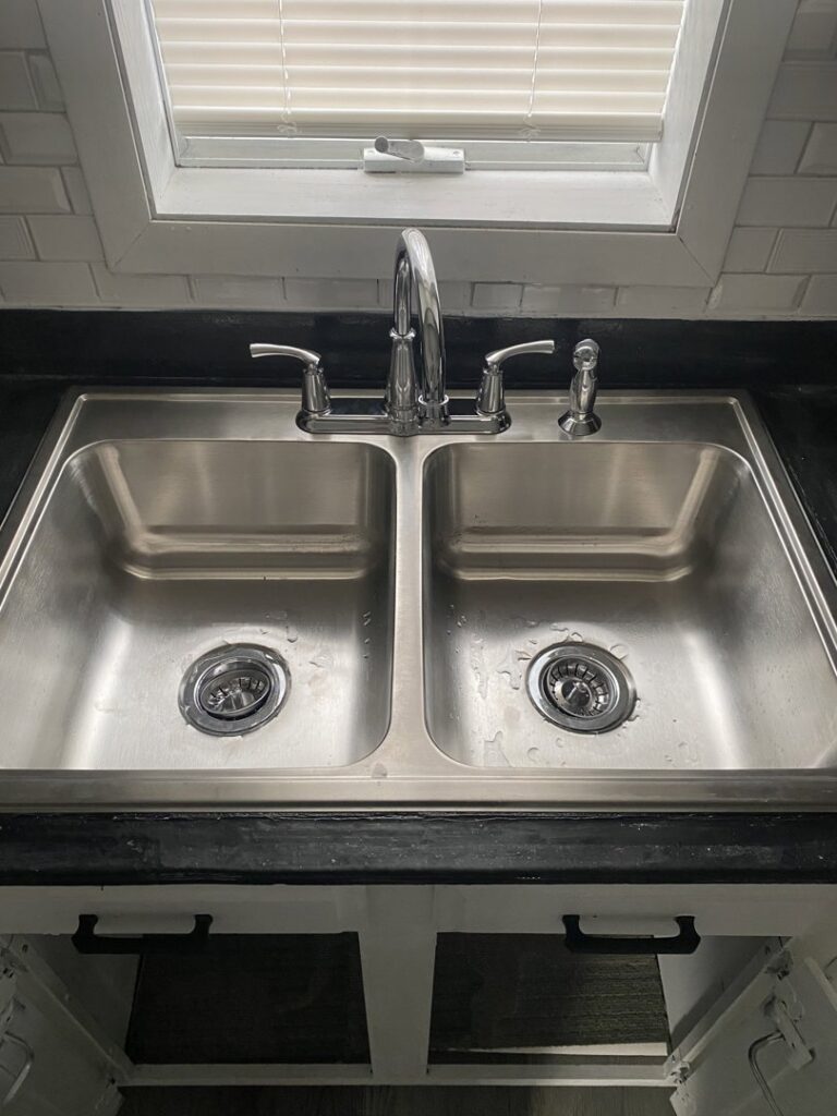 A newly installed kitchen sink and faucet, showcasing plumbing work by Aaron's Handyman Service in Tucson, AZ.