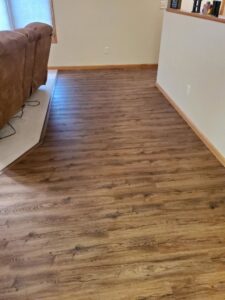 Newly installed laminate flooring in a living area by Honey Bee's Handyman Services in Hastings, NE.