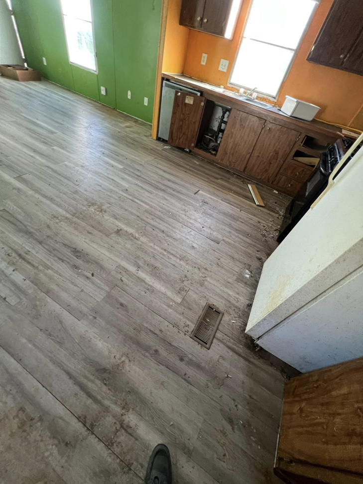 Newly installed laminate flooring in a kitchen, a handyman service completed by Cosa Cleanouts & Junk Removal in Topeka, KS.