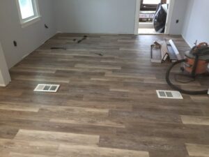 New laminate flooring being installed in a room by Carl Gardner Contracting in Syracuse, NY.
