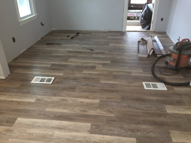 New laminate flooring being installed in a room by Carl Gardner Contracting in Syracuse, NY.