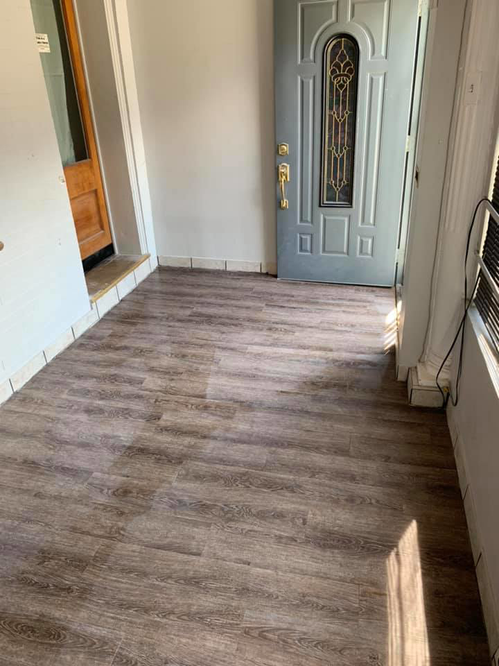 Newly installed wood-look laminate flooring in an entryway by Tawfiq Services LLC in Philadelphia, PA