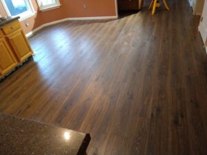 Newly installed laminate or engineered wood flooring in a kitchen and dining area, a project by Blas Home Remodeling LLC in New Castle, DE.
