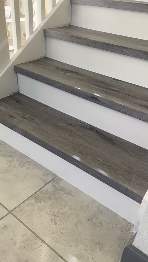 Newly installed laminate wood-look stair treads with white risers by SD Masters in Miami, FL.