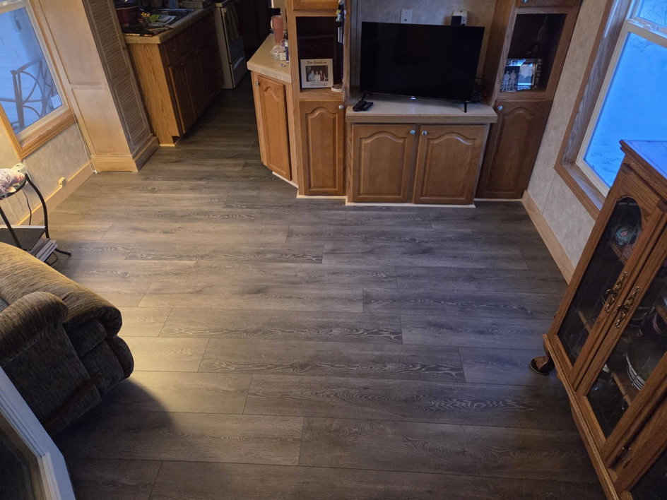 Newly installed laminate or vinyl plank flooring in a living area by Joe Norton's Handyman Service, offering flooring services in Williston, ND.