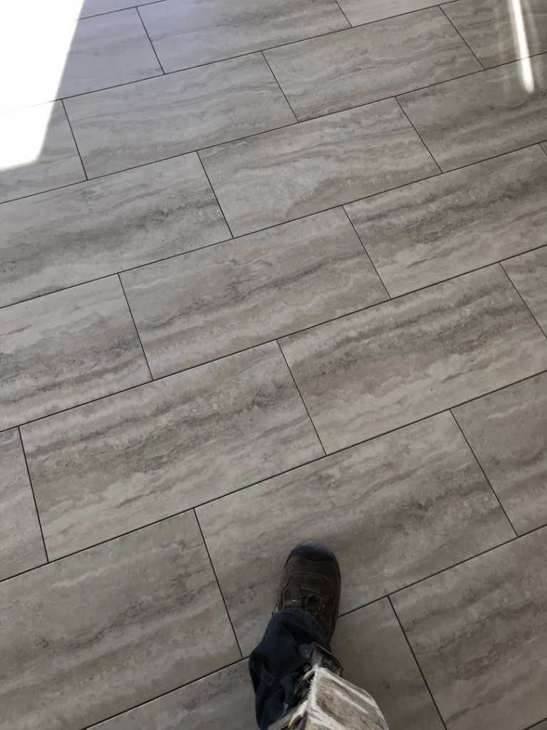 Close-up of newly installed large format tile flooring by Fueled Up Flooring- Justin Watruba in Eau Claire, WI.
