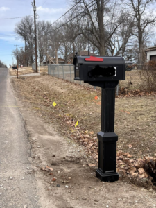 A newly installed black mailbox by the roadside, a service provided by Bill's Handyman Services in Anchorage, AK.