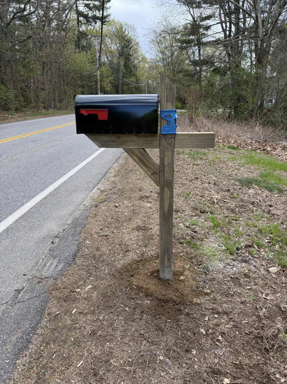 A new black mailbox installed on a wooden post by Daniels Handyman Services in Warwick, RI.