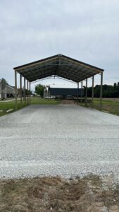 A newly constructed metal carport structure with a gravel base, built by Northcross Restoration Inc in Memphis, TN.