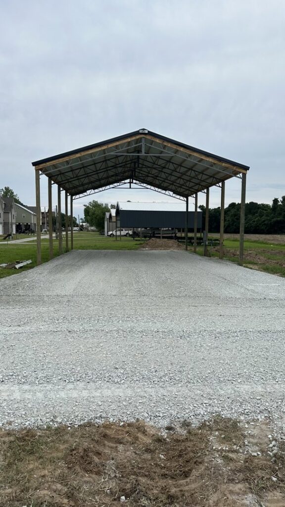 A newly constructed metal carport structure with a gravel base, built by Northcross Restoration Inc in Memphis, TN.