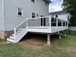 A newly installed outdoor deck with white railings and black balusters, built by RW Contracting Phila, LLC in Philadelphia, PA.