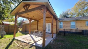 A newly constructed wooden patio cover addition and house siding by Finesse Painting and Remodeling in Fort Worth, TX.