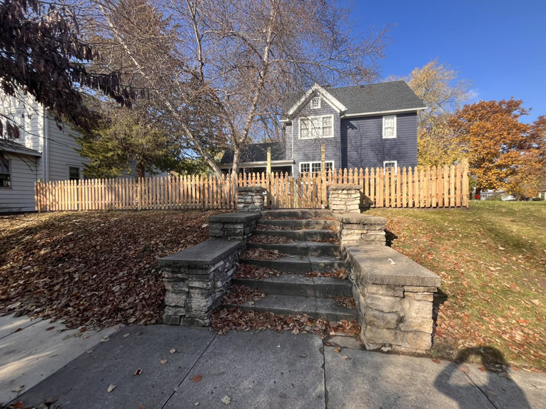 A newly installed wooden picket fence surrounding a house by McDonald Residential Contracting in Ames, IA.