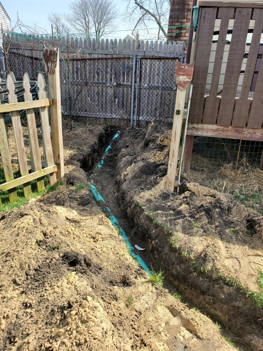 Newly installed plumbing pipes visible in an excavated trench for Hessville Plumbing in Hammond, IN.