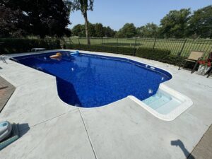 A newly installed pool liner and steps, showcasing a clean blue pool by Heatwave Pools LLC in Flint, MI.
