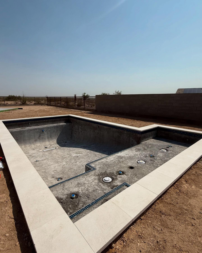 A new pool shell with coping and plumbing installed, ready for plastering by Prado & Sons Pool Plastering, Inc. in Glendale, AZ.