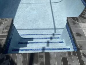 Close-up of newly tiled and plastered pool steps, showcasing quality craftsmanship by JJB Pools & Spas in Tampa, FL.