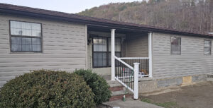 A newly installed white porch railing on a mobile home, demonstrating exterior repair services by Huntington Home Repair in Huntington, WV.