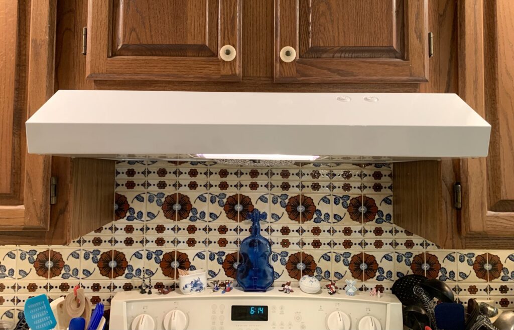 A newly installed white range hood above a kitchen stove, a completed kitchen upgrade by Folmar's Handyman & Remodeling in Lincoln, NE.