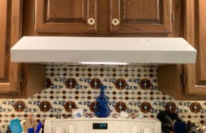 A newly installed white range hood above a kitchen stove, a completed kitchen upgrade by Folmar's Handyman & Remodeling in Lincoln, NE.