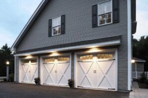 Newly installed white residential garage doors on a grey house by Overhead Door Company of Columbus in Columbus, GA.
