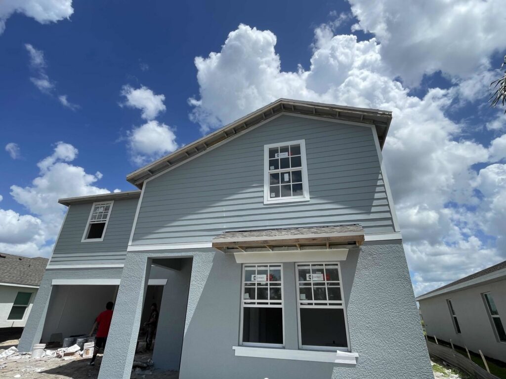 New residential home construction with blue siding and windows installed by M&J Florida Enterprise Llc in Orlando, FL.