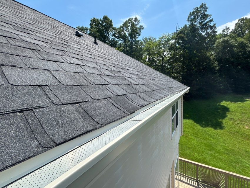 Close-up of a newly installed roof with new gutters and gutter guards by A&M Roofing in Springfield, VA.