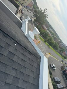 A newly installed shingle roof with white decorative trim on a commercial building by Usa Construction of Danbury LLC in Danbury, CT.