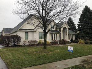 A residential home with a newly installed roof and an Elk Building Services sign on the lawn in Toledo, OH.