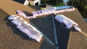 An aerial view of a residential roof with bundles of new shingles stacked, ready for installation by Element Enterprises in Kansas City, MO.