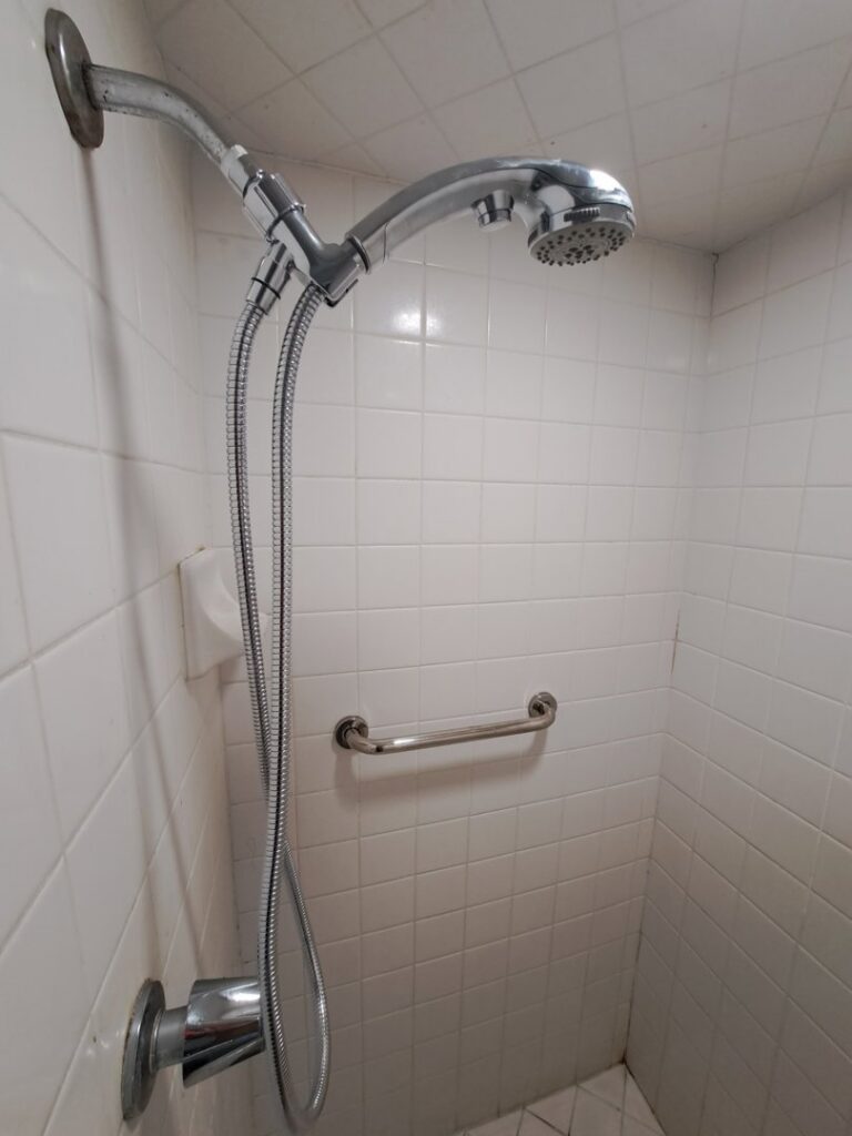 A new shower head system and grab bar installed in a tiled shower by Victor White Handyman in Long Beach, CA