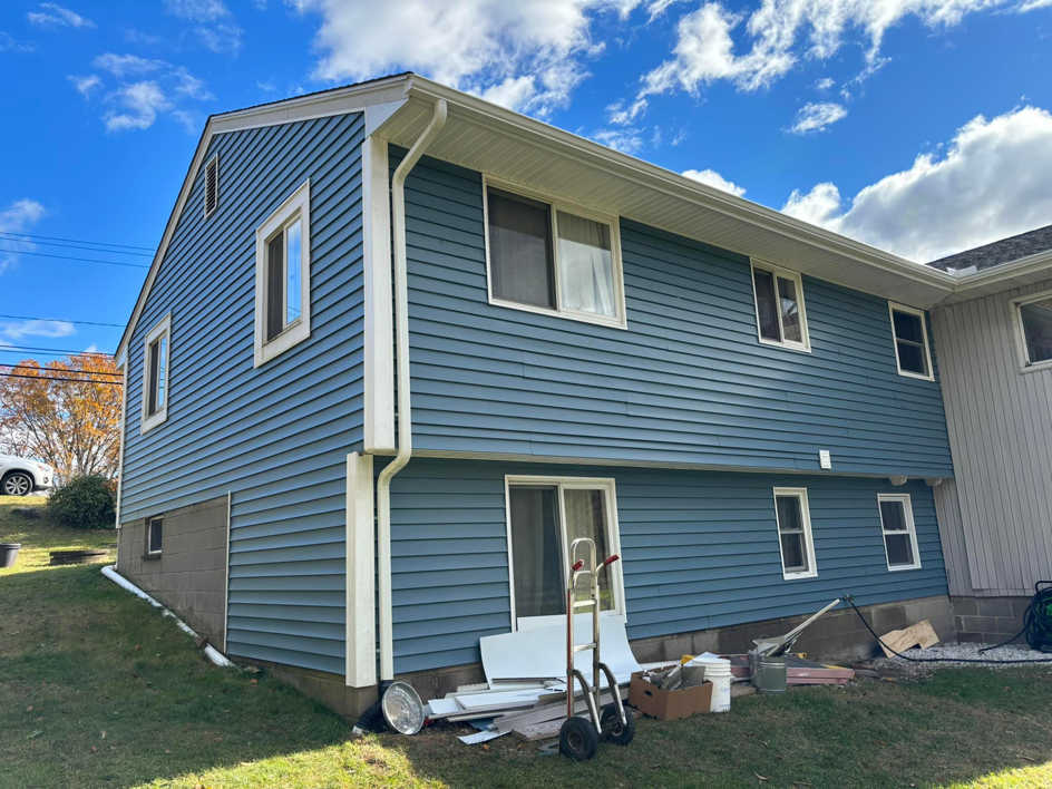 A house with newly installed blue siding and gutters, completed by GGS General Construction LLC in Plano, TX.