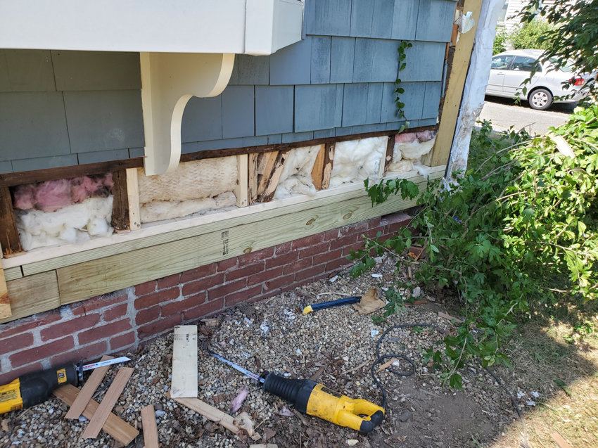 Exterior view of a house with new wooden sills installed above the brick foundation by Richard C. Michalak in Worcester, MA.