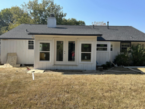 A newly added sunroom or extension with new windows and French doors on a house exterior by Old Things Created New Handyman Service in Springdale, AR.