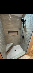 A newly installed tiled shower with a bench and niche by Craft Tile Co in Springfield, MO.