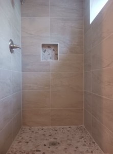 A newly installed tiled shower with a built-in niche, completed by RS handyman llc in Kenai, AK.