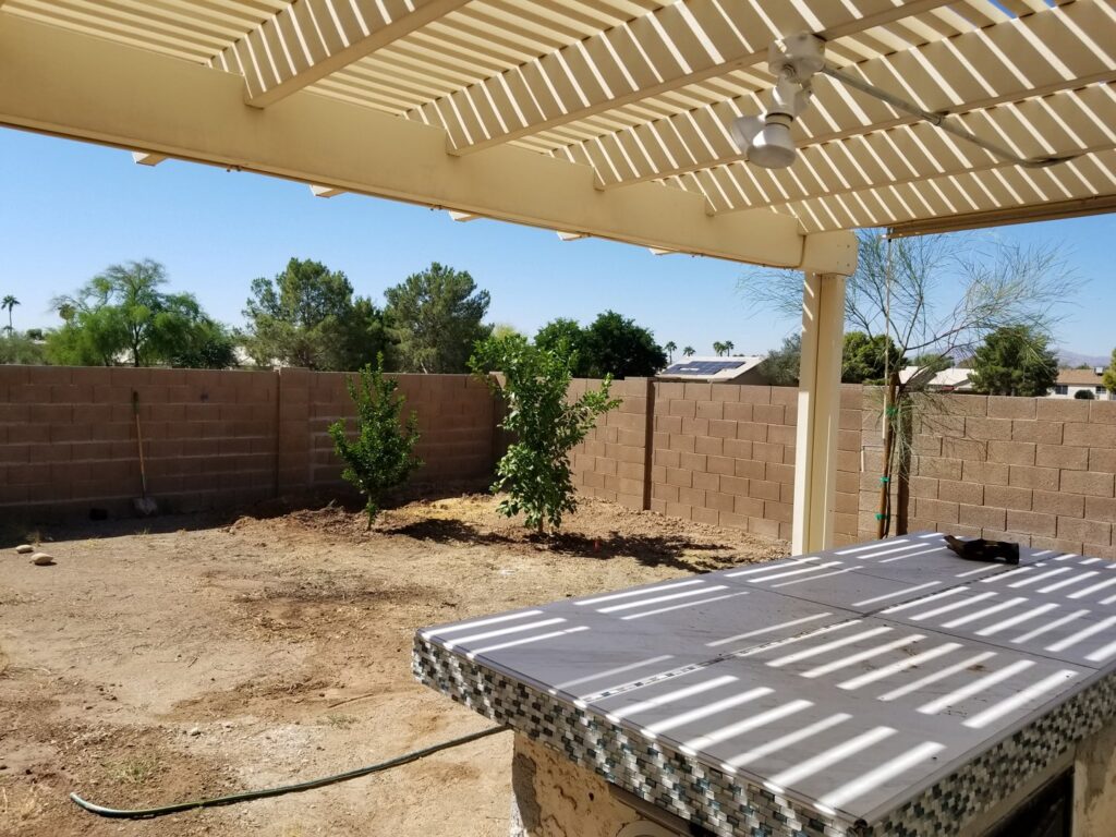 A newly landscaped backyard featuring two young trees recently planted by No Bull Trees in Surprise, AZ.