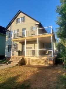 A newly built two-story porch with black metal railings by Indoor/Outdoor Home Repairs in Parma, OH.