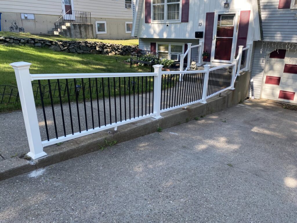 A new white and black exterior railing installed along a driveway by Prenga Remodeling in Orange, CT