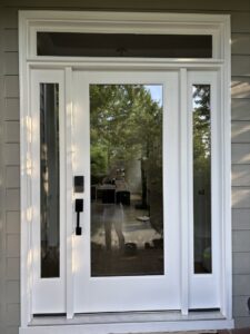 A newly installed white front door with glass panels and sidelights by NC Siding and Windows in Raleigh, NC