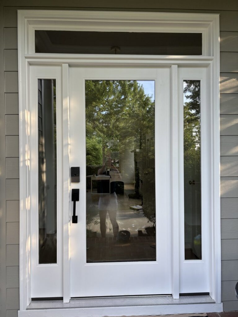 A newly installed white front door with glass panels and sidelights by NC Siding and Windows in Raleigh, NC