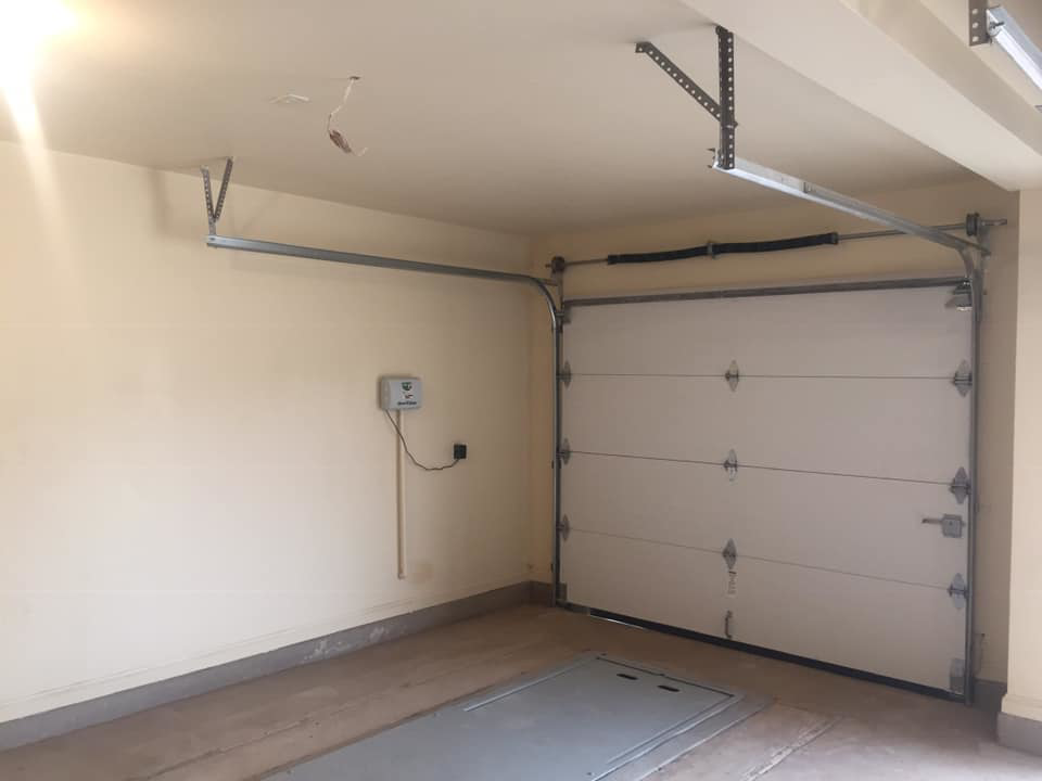 A new white garage door with tracks and springs installed by Big Red Overhead Door, LLC in Moore, OK.