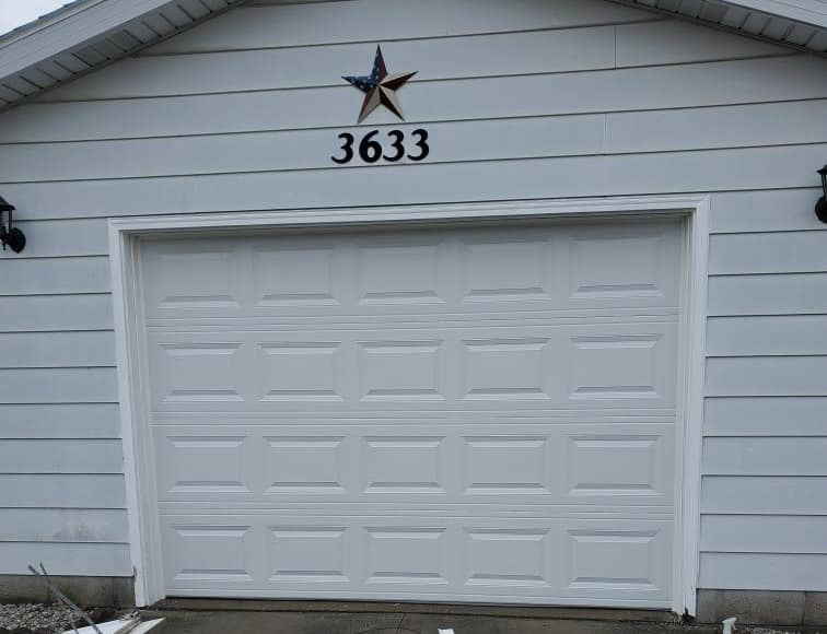 A new white garage door with house numbers above, installed by Lucas Overhead Doors in Erie, PA.