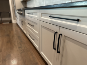 Newly installed white kitchen cabinets with black handles by Sherwood Painting Services in Mooresville, NC.