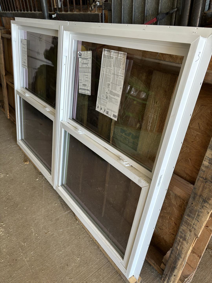 Two new white-framed replacement windows for installation by E.L.Y Siding Company in Buckner, MO
