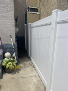 A newly installed white vinyl privacy fence in a side yard by AC Fence and Ironworks in Philadelphia, PA.