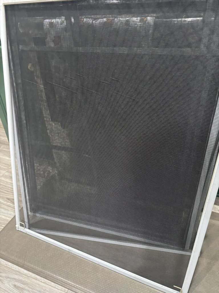 A newly installed or repaired window screen, a service provided by JJConstruction203 LLC in Charlotte, NC.