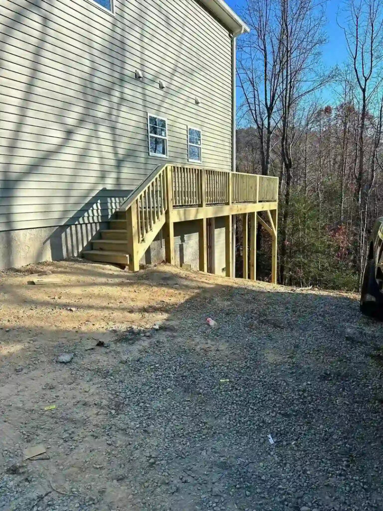 A newly constructed wooden deck and stairs on the side of a house by Bryder Construction in Greenville, SC.